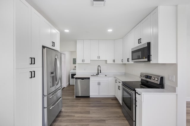 kitchen featuring stainless steel appliances, light countertops, visible vents, white cabinetry, and a sink