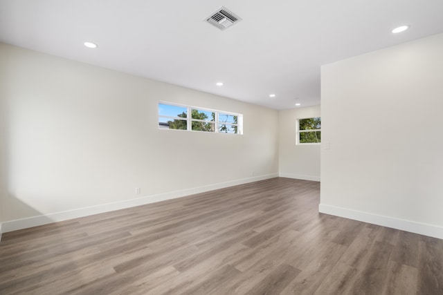 unfurnished room with recessed lighting, light wood-type flooring, visible vents, and baseboards