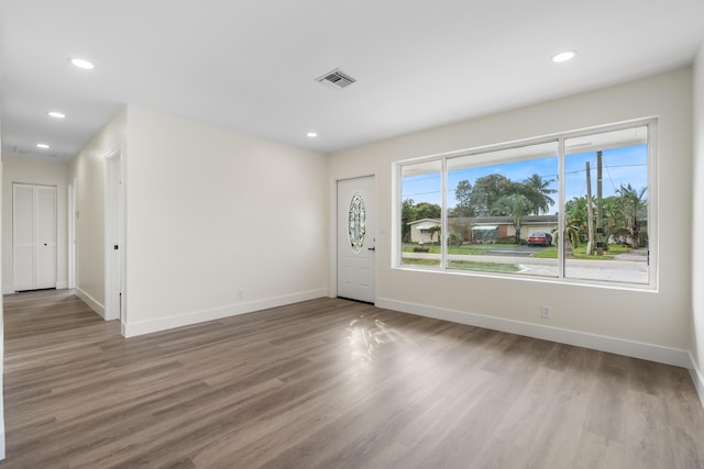 entryway with baseboards, wood finished floors, visible vents, and recessed lighting