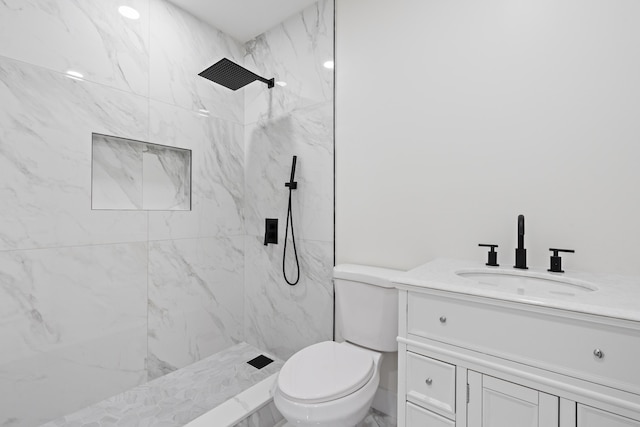 bathroom featuring toilet, a shower stall, and vanity