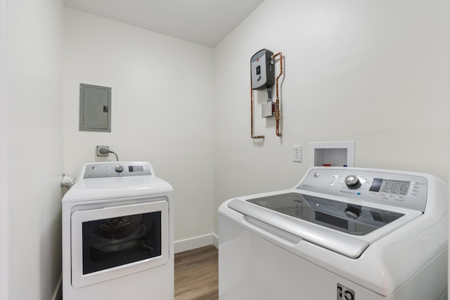 laundry room with laundry area, wood finished floors, baseboards, washer and dryer, and electric panel