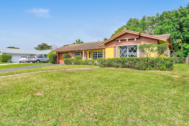 single story home with an attached garage, driveway, and a front yard