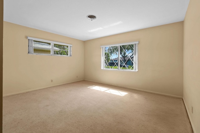 unfurnished room featuring carpet flooring, visible vents, and baseboards