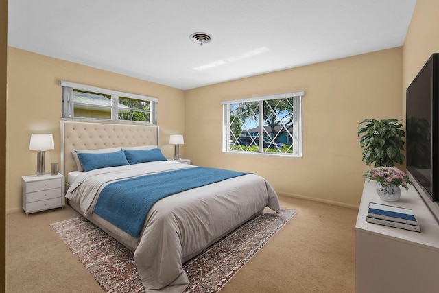 carpeted bedroom featuring baseboards and visible vents