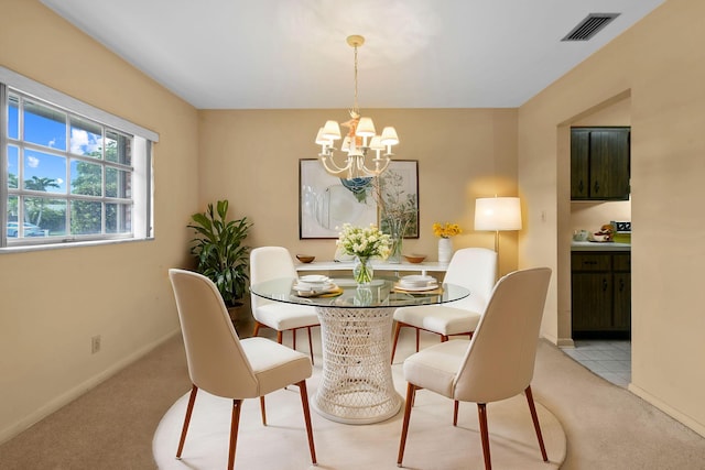 dining area featuring an inviting chandelier, baseboards, visible vents, and light colored carpet