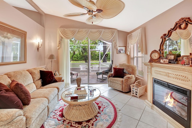 living room with light tile patterned floors, ceiling fan, and a glass covered fireplace