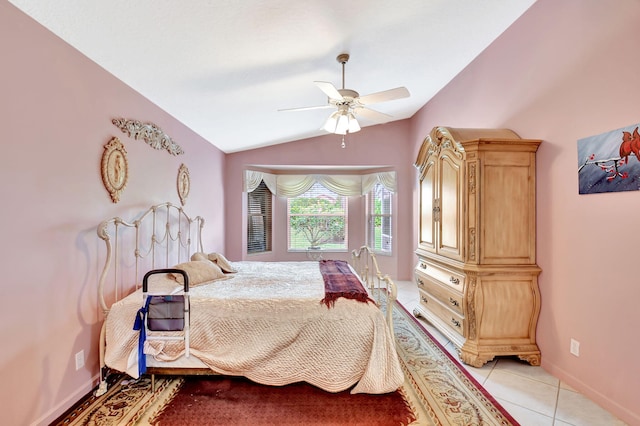 bedroom with vaulted ceiling, ceiling fan, light tile patterned floors, and baseboards