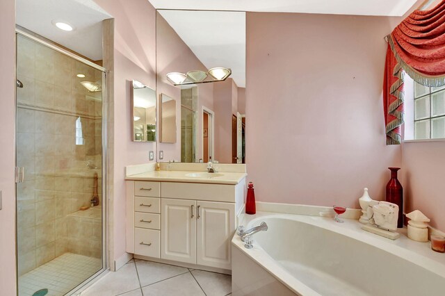 full bath featuring a stall shower, a bath, two vanities, tile patterned flooring, and a sink