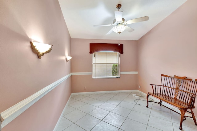 sitting room featuring light tile patterned flooring, ceiling fan, and baseboards