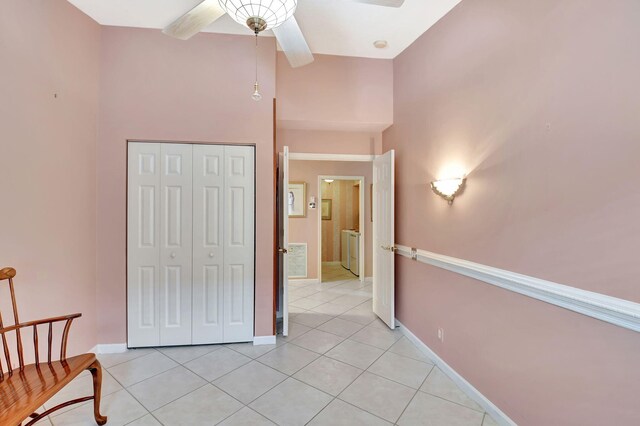 sitting room with light tile patterned flooring, a ceiling fan, and baseboards