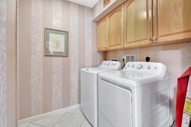 laundry room with independent washer and dryer, cabinet space, light tile patterned flooring, and baseboards