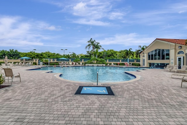 community pool featuring a patio area and fence