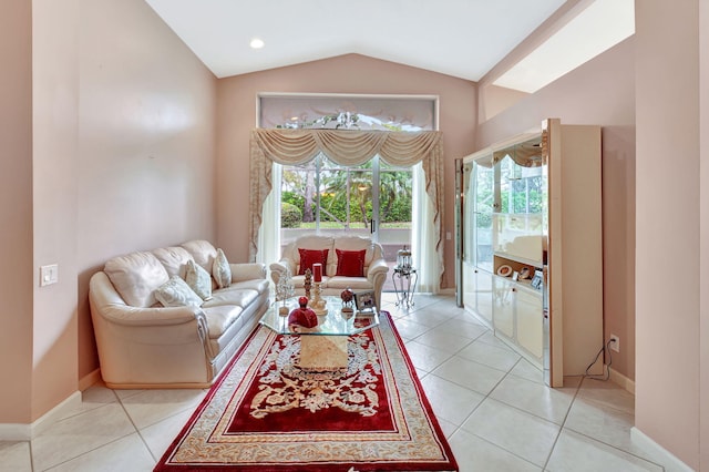 living room with light tile patterned floors, baseboards, and vaulted ceiling