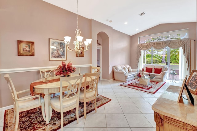 dining area with lofted ceiling, arched walkways, light tile patterned flooring, visible vents, and an inviting chandelier