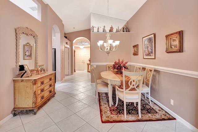 dining area featuring arched walkways, a notable chandelier, visible vents, light tile patterned flooring, and vaulted ceiling