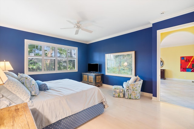 bedroom with baseboards, ornamental molding, arched walkways, and wood finished floors