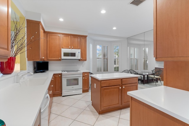 kitchen with light countertops, white appliances, a sink, and visible vents