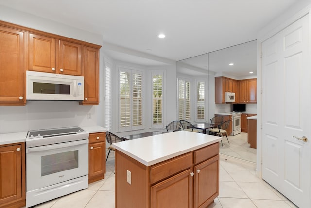 kitchen featuring light tile patterned floors, white appliances, and recessed lighting