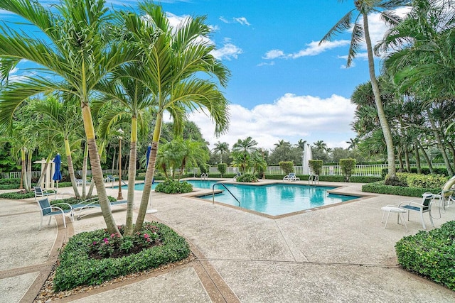 pool with a patio area and fence