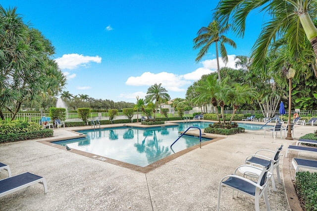 pool with a patio and fence