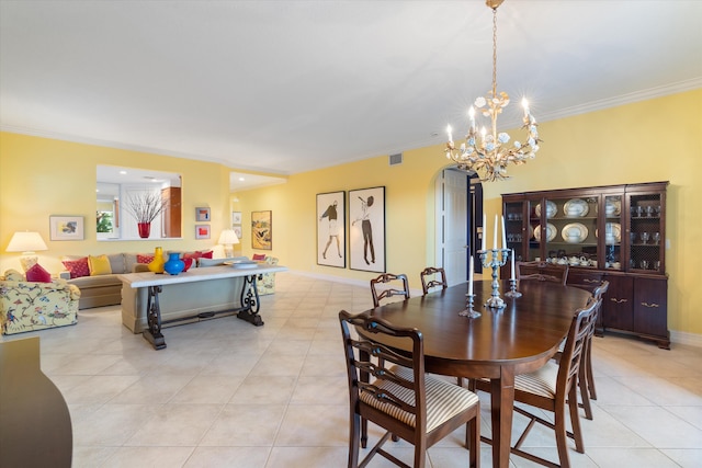 dining room with arched walkways, light tile patterned floors, visible vents, and crown molding