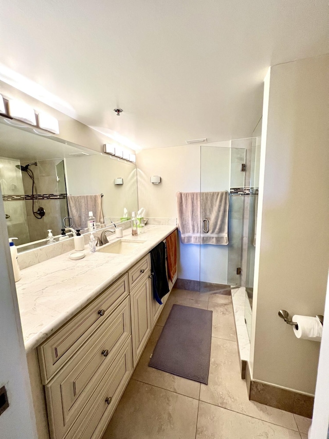 full bathroom with baseboards, a stall shower, vanity, and tile patterned floors