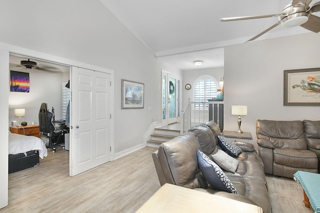 living room with a ceiling fan, light wood-type flooring, vaulted ceiling, and baseboards