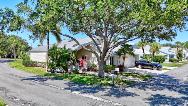 view of front of home featuring a garage, driveway, and metal roof