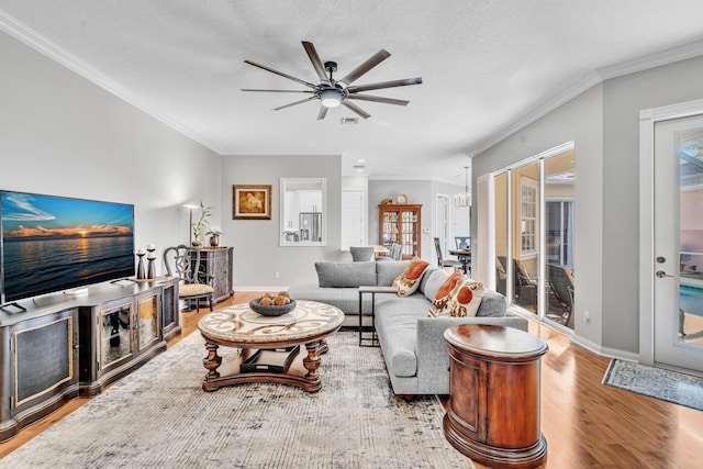 living room with light wood-type flooring, baseboards, and crown molding