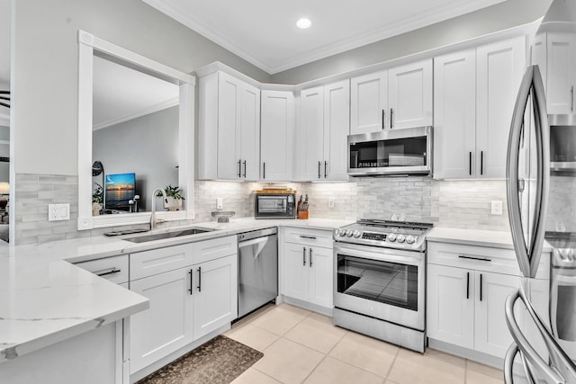 kitchen with white cabinetry, stainless steel appliances, a sink, and ornamental molding