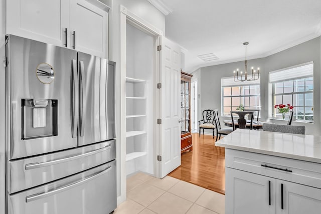 kitchen featuring light tile patterned floors, ornamental molding, white cabinets, and stainless steel fridge with ice dispenser