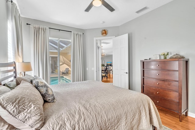 bedroom with access to exterior, a ceiling fan, visible vents, and wood finished floors