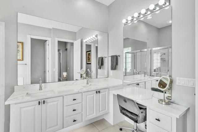 bathroom with a stall shower, double vanity, a sink, and tile patterned floors