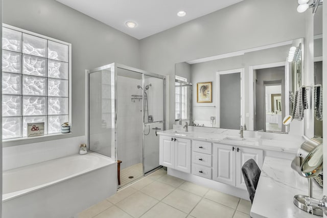 full bathroom featuring double vanity, a garden tub, tile patterned flooring, a shower stall, and a sink