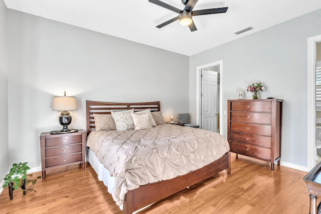 bedroom with baseboards, visible vents, ceiling fan, and light wood finished floors