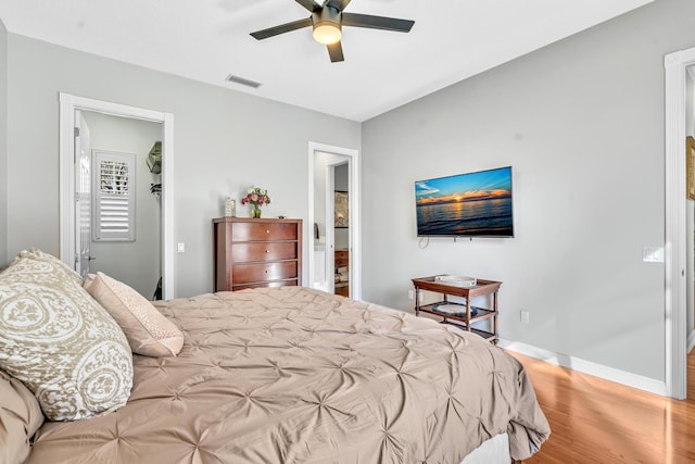 bedroom featuring baseboards, visible vents, ceiling fan, and wood finished floors