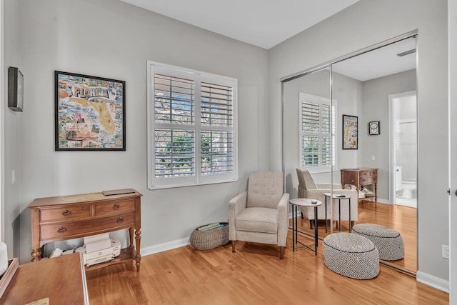 living area with light wood-style flooring and baseboards