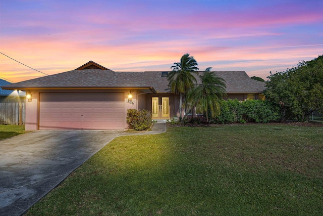 view of front facade featuring a front yard, driveway, an attached garage, and stucco siding