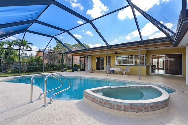 view of pool featuring a pool with connected hot tub, glass enclosure, a patio, and ceiling fan