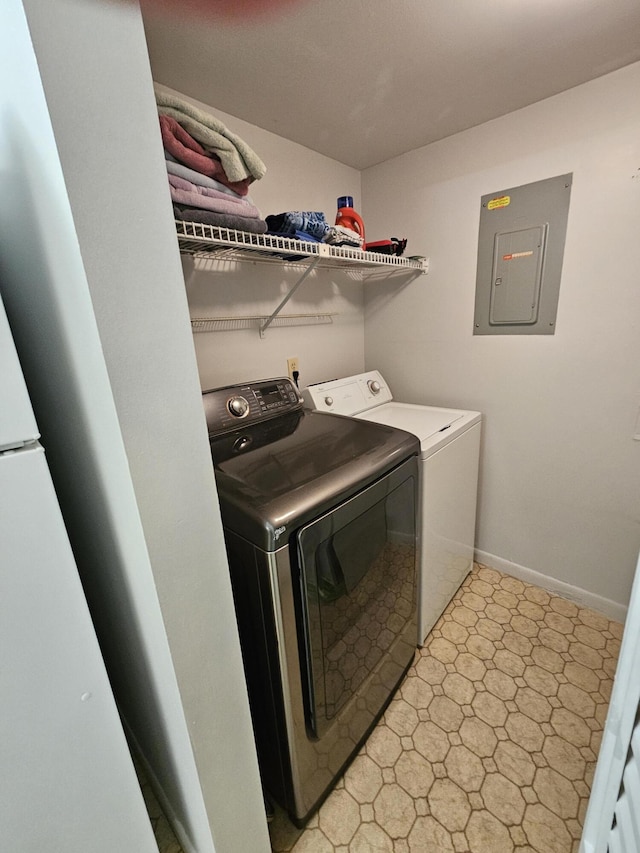 laundry area with laundry area, electric panel, baseboards, and washer and clothes dryer