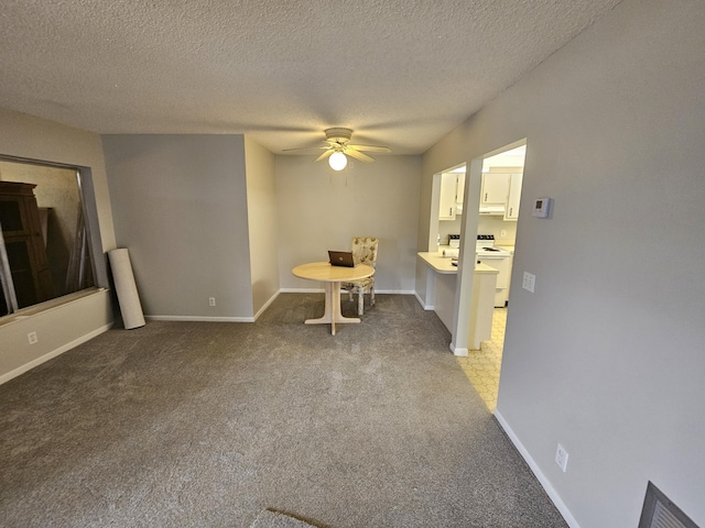 unfurnished dining area with carpet floors, baseboards, and a ceiling fan