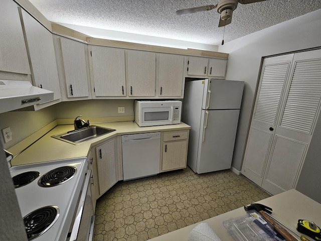 kitchen featuring light floors, light countertops, exhaust hood, white appliances, and a sink