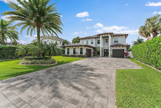 view of front of house with a front lawn, decorative driveway, and an attached garage