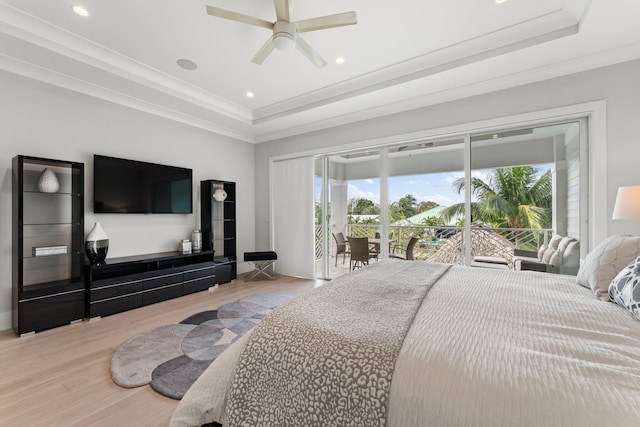 bedroom featuring recessed lighting, a tray ceiling, wood finished floors, and access to outside