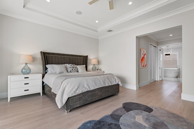 bedroom featuring visible vents, wood finished floors, baseboards, crown molding, and a raised ceiling