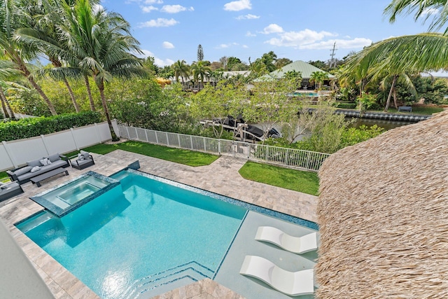 view of swimming pool with a pool with connected hot tub, a patio area, and a fenced backyard