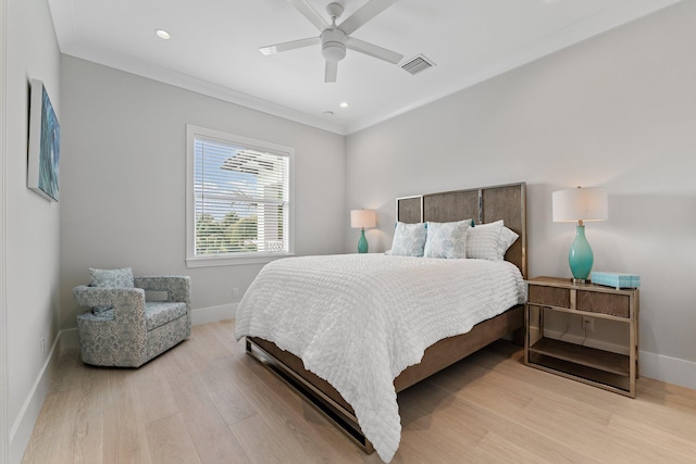 bedroom with light wood finished floors, visible vents, ceiling fan, baseboards, and ornamental molding