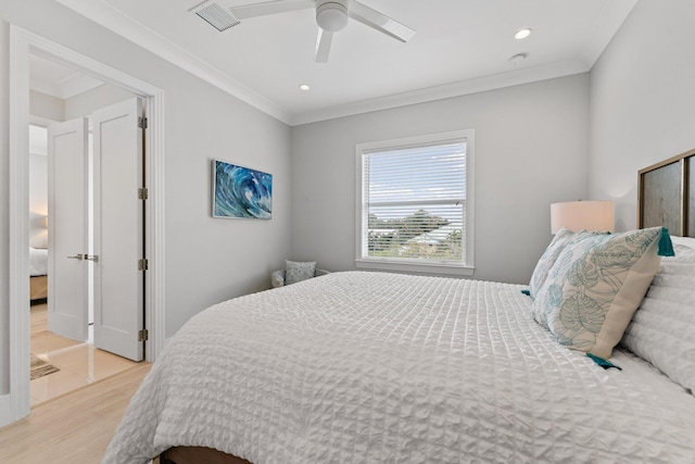 bedroom with light wood-type flooring, visible vents, ceiling fan, and crown molding