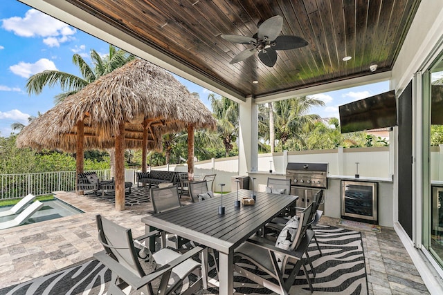 view of patio with a fenced backyard, an outdoor kitchen, a grill, and outdoor dining space