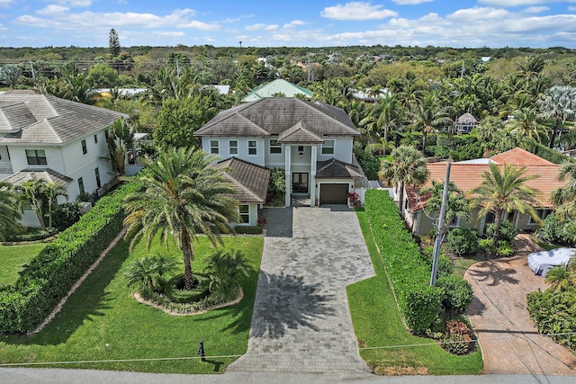 view of front of property with decorative driveway, a front lawn, and a tile roof